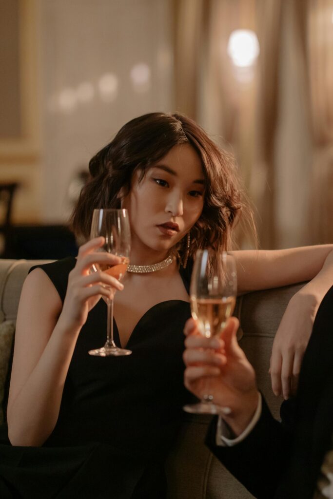 Lady in black dress drinking sparkling wine